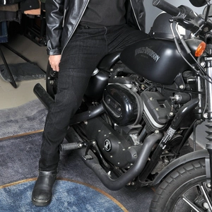 Men's protective motorcycle jeans in black denim shown in a professional riding stance