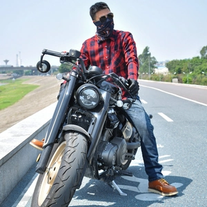 Retro plaid motorcycle riding shirt with protective gear on a vintage black motorbike
