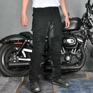 Detail of black motorcycle riding pants featuring reinforced knee pleats and utility pockets
