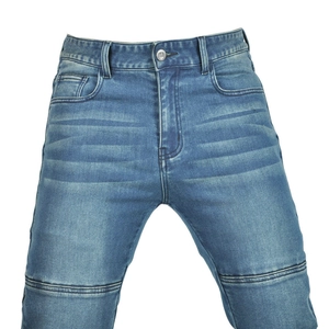 Detail of blue motorcycle jeans featuring distressed wash and reinforced stitching