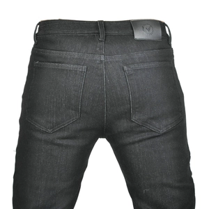 Detail view of motorcycle jeans with black leather logo patch and double rear pockets