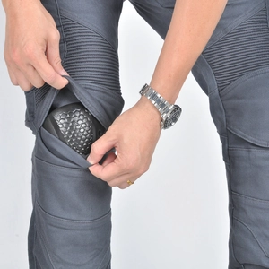 Dettaglio dei pantaloni moto grigi con protezione a nido d'ape e soffietti elastici sulle ginocchia