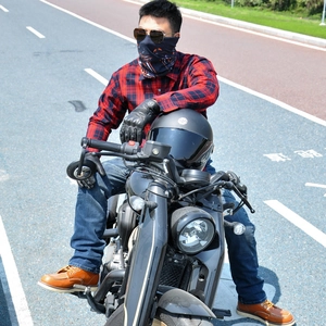 Outdoor street shot of a rider wearing a red checkered protective motorcycle shirt