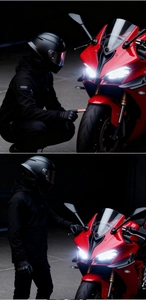Detail of professional black motorcycle jacket and helmet set with red racing bike