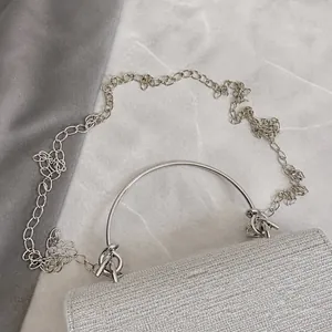 Details van zilveren handtas met strass-steentjes, metalen handvat en afneembare ketting