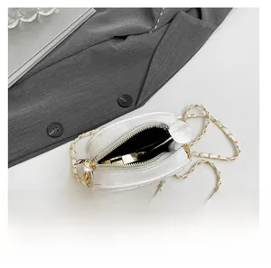 Top view of white quilted round bag interior showing cosmetics and gold chain strap