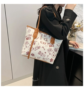 Détail du grand sac cabas blanc avec imprimés graffiti et lanières en cuir brun