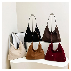 Fünf Hobo-Taschen in verschiedenen Farben mit silbernen Nieten auf weißen Podesten