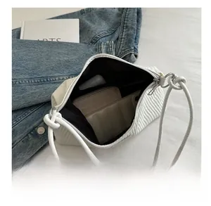 Vue intérieure montrant la grande capacité du sac à bandoulière blanc plissé