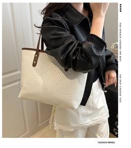 Detail of woven texture tote bag in beige leather with dark brown shoulder straps