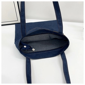 Detail view of denim tote bag showing interior lining and bronze contrast stitching
