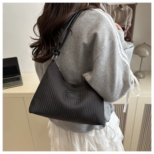 Détail du sac hobo plissé noir avec texture gaufrée et design de bandoulière fine