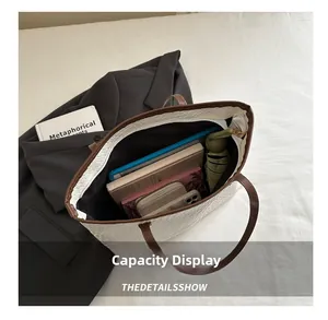 Top view of spacious white woven tote bag interior showing laptop and daily essentials