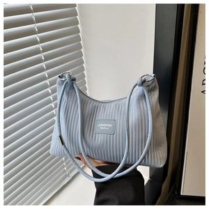 Détail du sac seau bleu clair montrant la texture plissée et le logo de la marque
