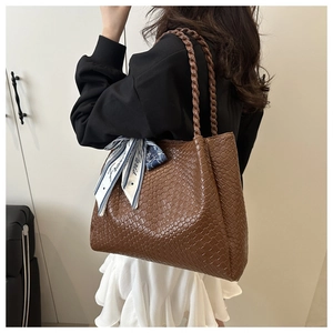 Vue détaillée du sac cabas marron tressé avec poignées et foulard en soie décoratif