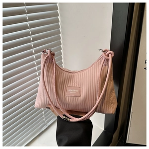 Détail d'un sac demi-lune plissé rose avec étiquette tissée tendance et anneaux métalliques