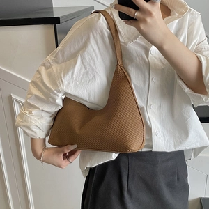 Minimalist caramel brown woven crescent shoulder bag shown in a stylish mirror selfie