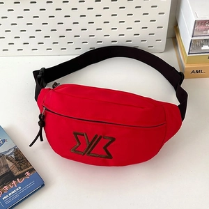 Detail of red nylon waist bag featuring dark brown embroidered logo and black zipper closure