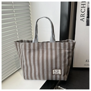 Texture détaillée du sac fourre-tout en velours côtelé rayé gris et blanc avec patch