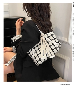 Makro-Detail der karierten Tweed-Schultertasche mit stilvollem Band und Webstruktur