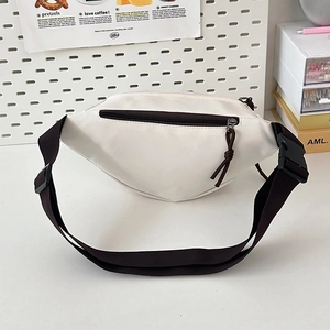 Detail of a minimalist cream-colored crossbody chest bag with contrast brown zippers and strap