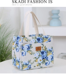 Detail of floral canvas tote bag showing thick cotton handles and leather brand logo patch