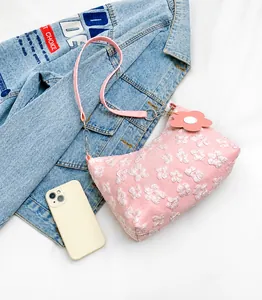 Detail of pink floral fabric underarm bag with silver chain and flower charm