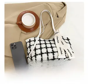 Nahaufnahme der schwarz-weißen Tweed-Tragetasche mit elegantem Band und Accessoires