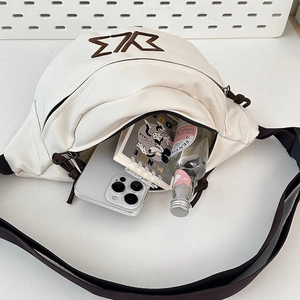 Detail showing the large interior capacity of this canvas crossbody bag with internal items