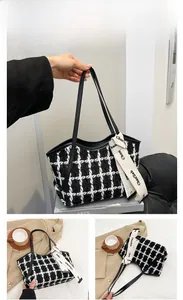Detailansicht der schwarz-weiß karierten Tweed-Handtasche mit elegantem Kontrast-Schleifenband