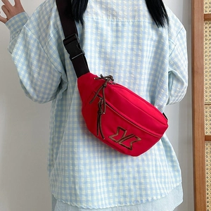 Detail of red nylon chest bag showing brown adjustable strap and buckle for daily commute