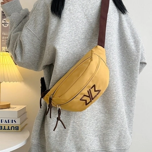 Detail of yellow nylon crossbody bag with ZYZ embroidery and woven brown strap