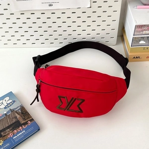 Detail of red canvas waist bag with adjustable black strap and brown embroidered logo
