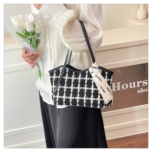 Detail der Tweed-Schultertasche mit Lederriemen und dekorativem Seidenschal-Accessoire