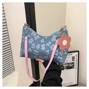 Detail of blue floral jacquard fabric with pink leather strap and flower charm on bag
