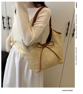 Détail du sac cabas en paille avec nœud en cuir et bandoulière contrastante élégante