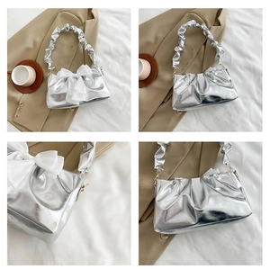 Detail of silver metallic pleated cloud bag with white mesh bow and chic texture