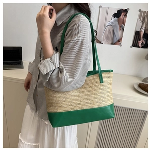 Détail du sac cabas en paille tressée avec bordure et bandoulière en cuir vert vif