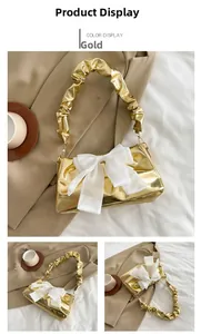 Detail of golden chic bag with large white chiffon bow and ruched handle design