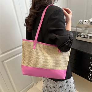 Grand sac cabas beige en paille tressée avec anses et finitions en cuir rose sur modèle