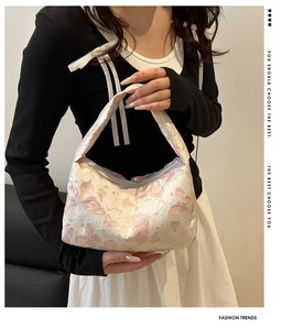 Détail du sac à main crème avec motif papillon rose scintillant et fermeture éclair