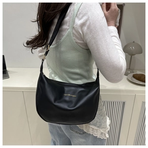 Detail of black leather crescent bag with gold Fashion & Bags logo and adjustable strap