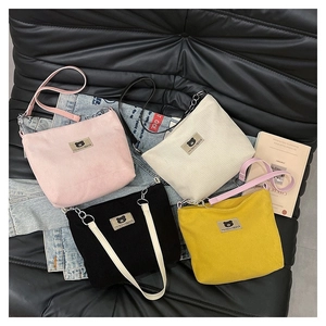 Corduroy bucket shoulder bags in pink, beige, black, and yellow with metal chain straps