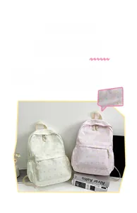 Dettaglio del motivo con gatto e fiocco sullo zaino da studente bianco e rosa