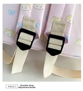 Dettaglio dello zaino rosa con fibbie regolabili per spallacci e motivi a gatto