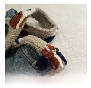 Détail du sac seau en jean vintage et peluche léopard montrant la texture et la couture