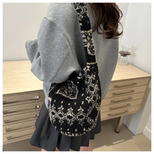 Détail du sac à bandoulière minimaliste en peau de mouton avec motif jacquard noir et blanc