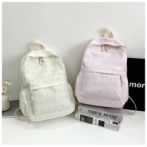 Dettaglio di stampe con gatti e fiocchi su zaini in tela resistente in rosa e beige
