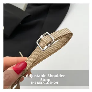 Detail view of the adjustable woven shoulder strap with metallic silver buckle buckle