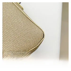 Close-up of woven fabric texture and beige leather trim on a stylish baguette bag